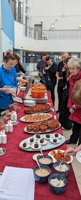 People trying out food at our food stall People trying out food at our food stall
